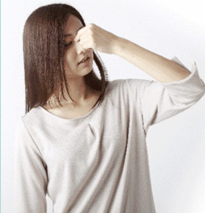 鼻をつまむ女性